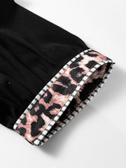 Black puff sleeve blouse with leopard print trim and striped cuff detail.