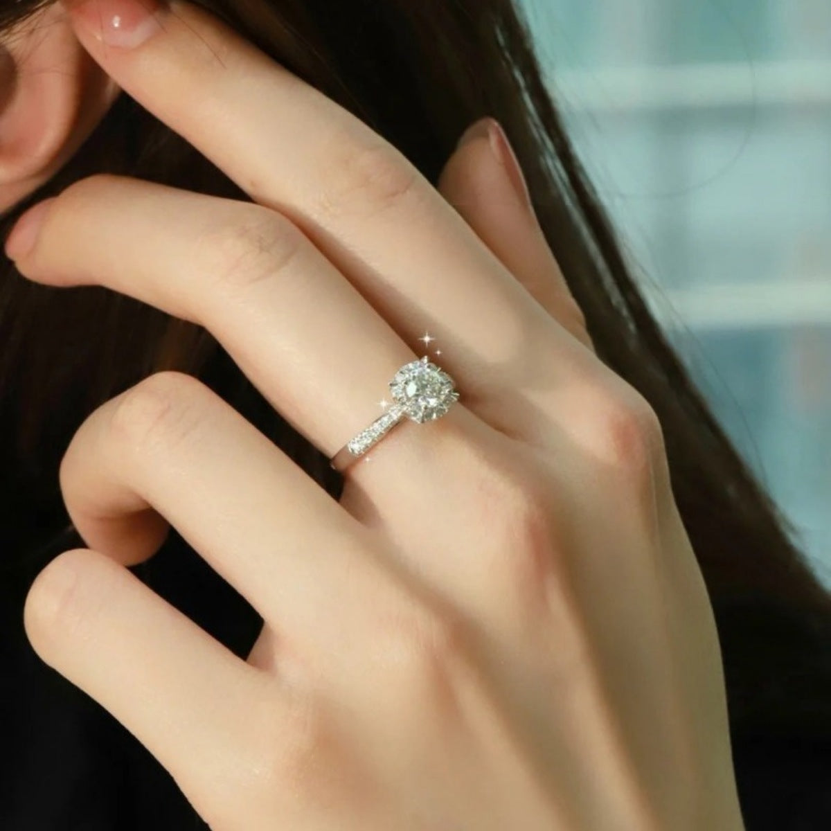 Sterling silver ring with a round brilliant moissanite center stone and pavé band.