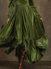 Dark green velvet maxi dress with voluminous sleeves and ruffled hem.