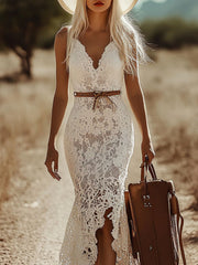 White lace V-neck sleeveless maxi dress with a brown belt and a suitcase.
