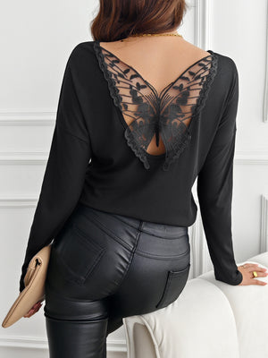 Black ribbed knit top with a sheer black lace butterfly detail on the back.