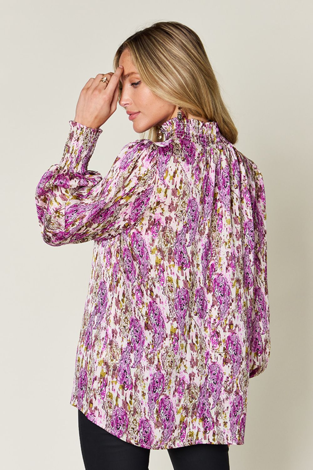 High neck abstract print blouse in red-violet with smocked cuffs and collar.