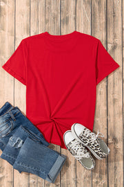 Red crew neck t-shirt with knotted hem detail, styled with jeans and leopard print sneakers.