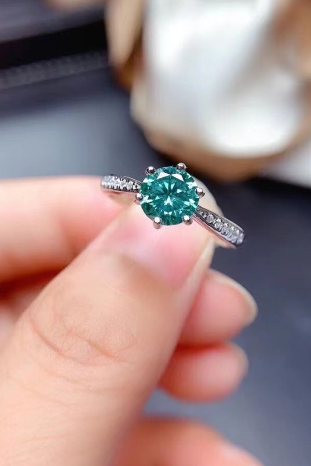 Teal moissanite solitaire ring with pave band in silver.