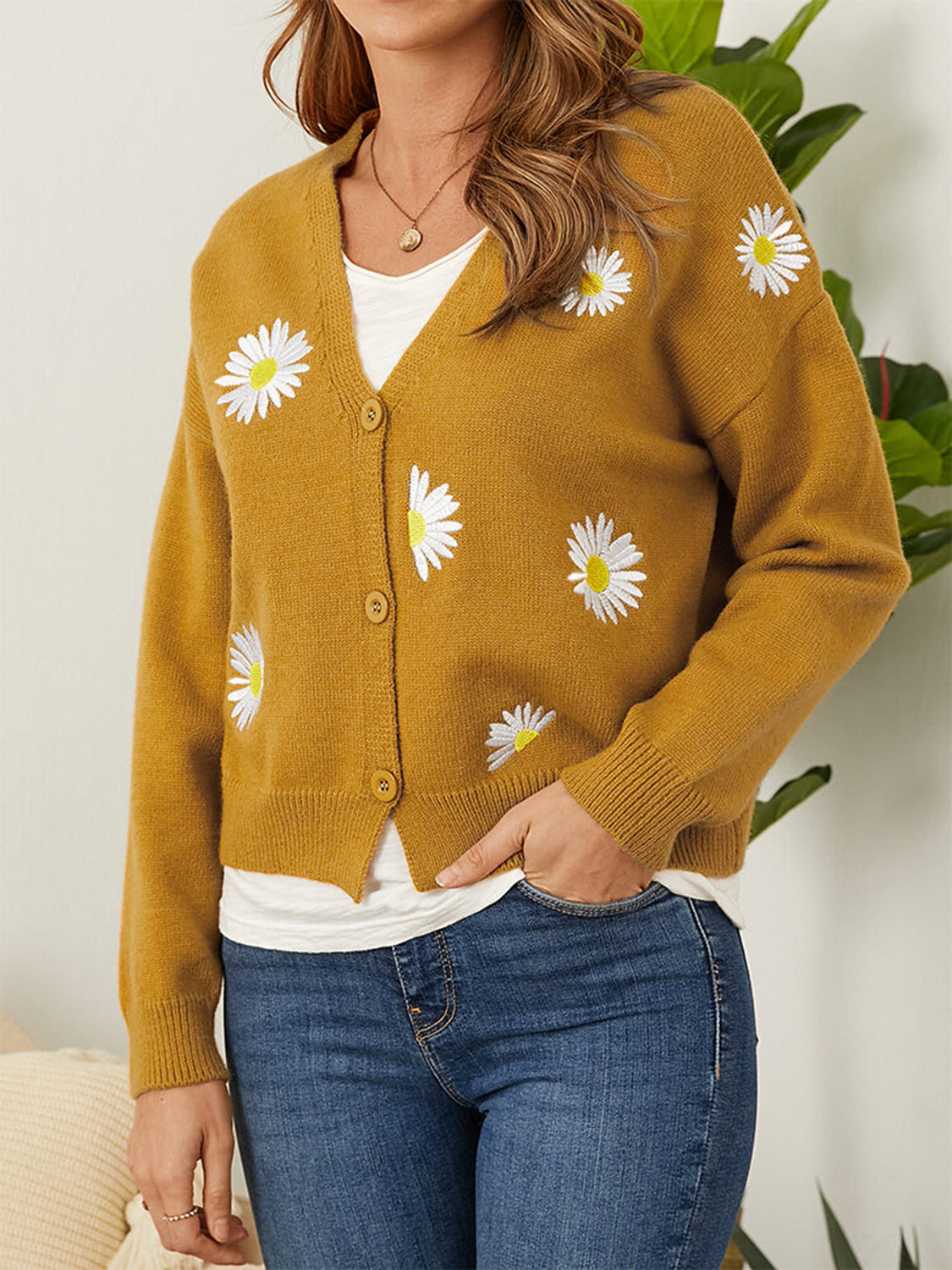 Mustard V-neck cardigan with embroidered daisies and button front.