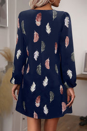 Navy feather print mini dress with long sleeves and a cutout neckline.