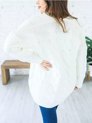 White cable knit duster cardigan with textured pattern and long sleeves.