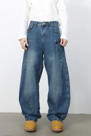 Medium wash denim balloon trousers with unique paneling and a relaxed fit.