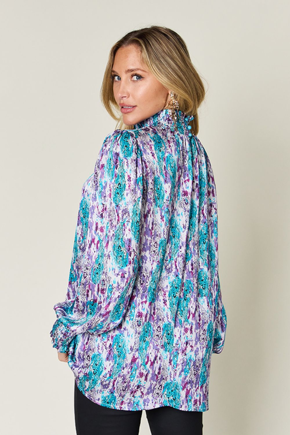High neck abstract print blouse with gathered cuffs in red-violet, sky blue, and green.
