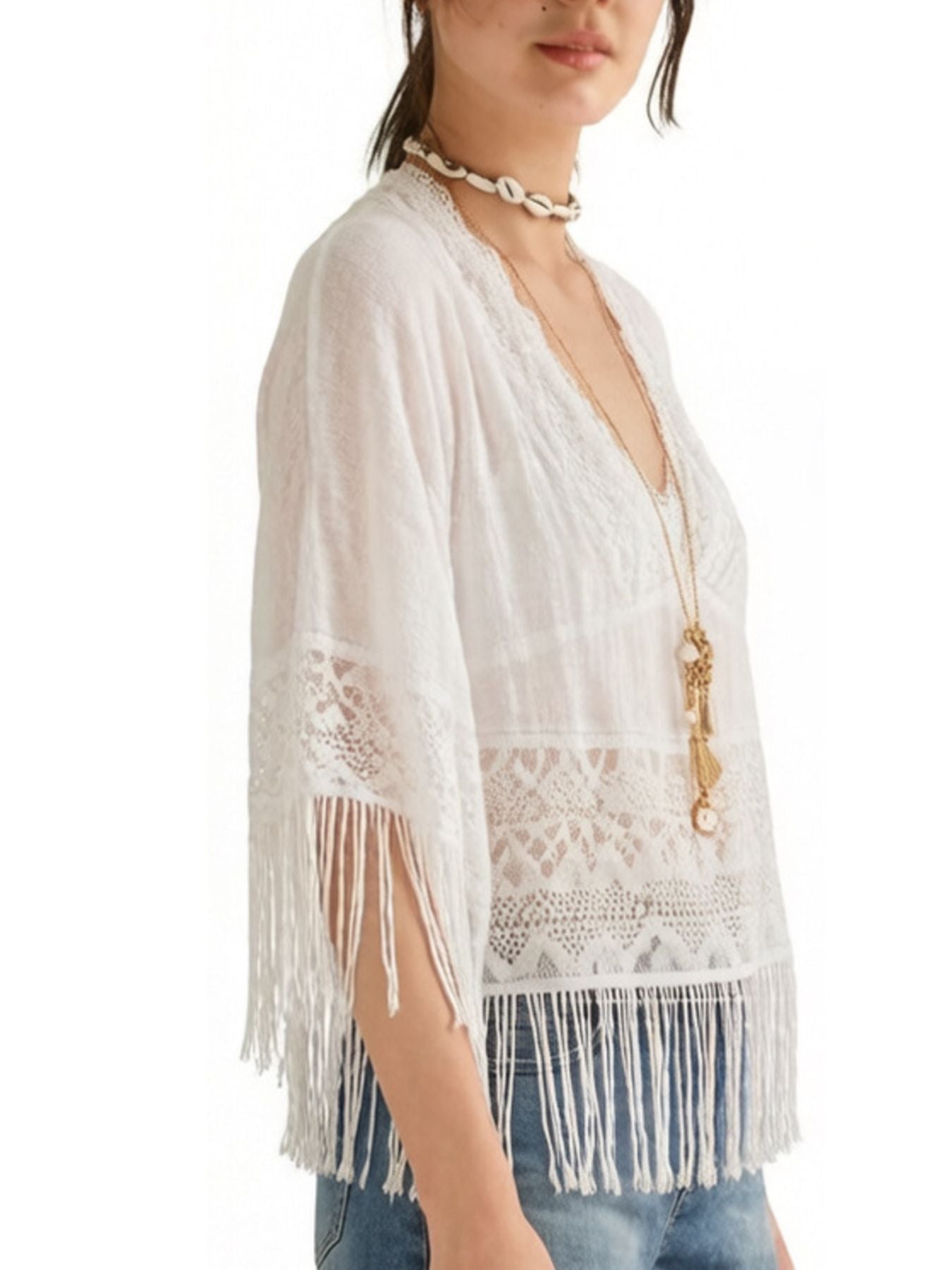 White bohemian lace cover-up with fringe and V-neck, styled with jeans.