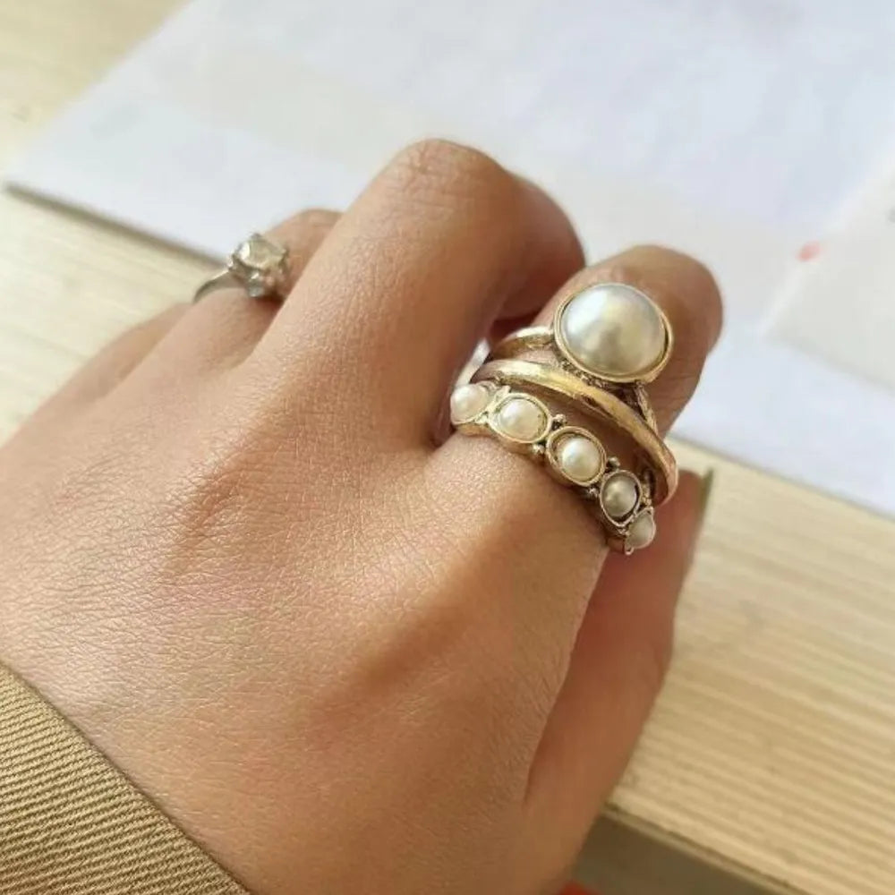 Gold stackable rings with pearl cluster and single pearl details.