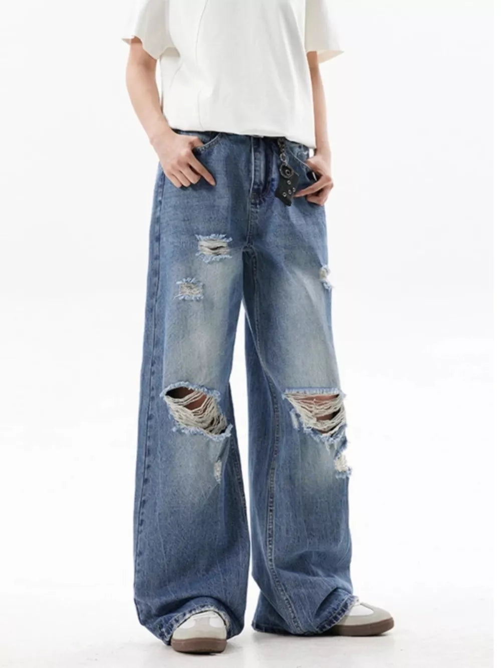Men's distressed wide-leg blue denim jeans with ripped details.