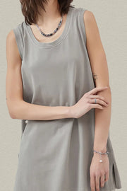 Relaxed gray tank top with scoop neck and side slits, styled with jewelry.