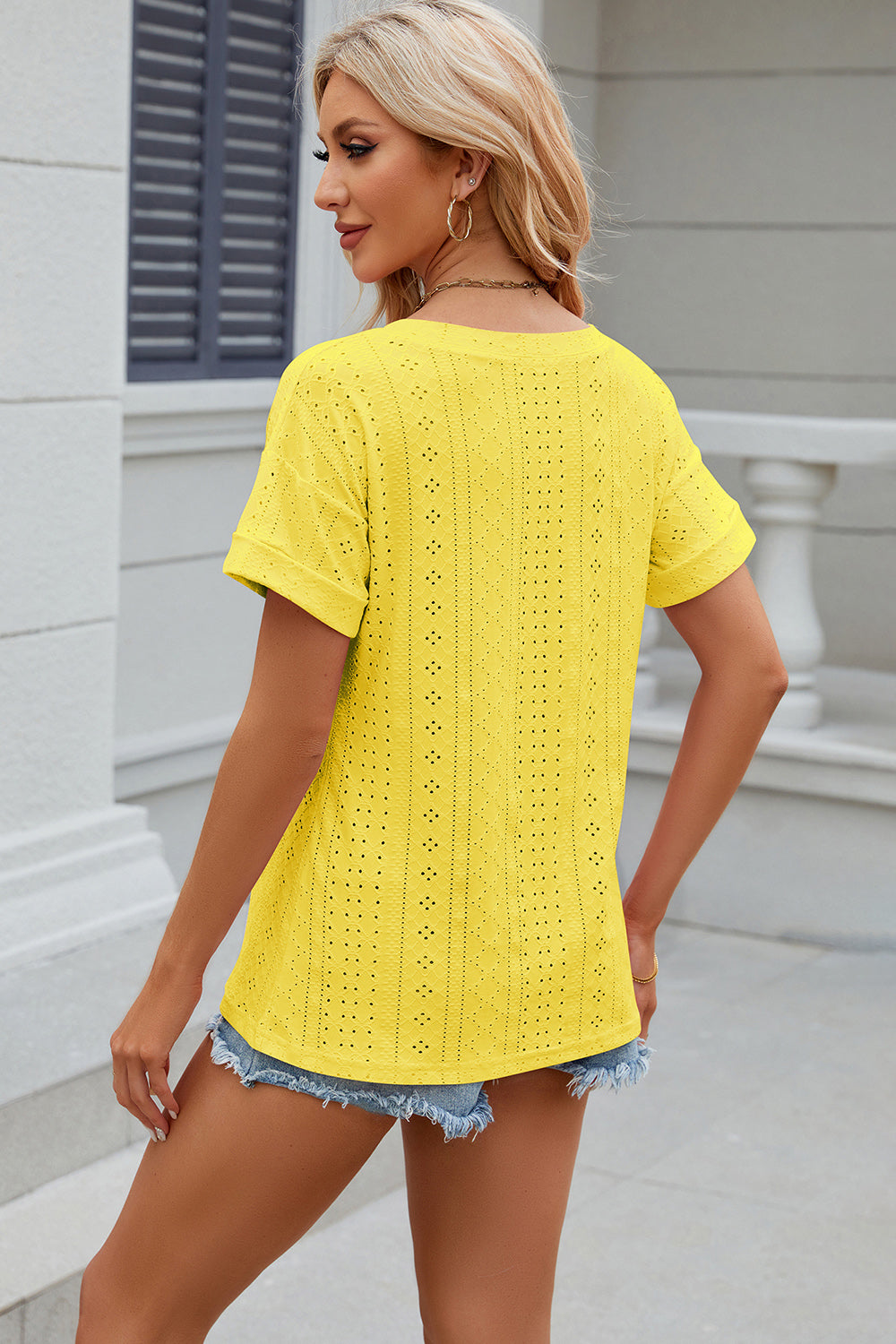 Yellow perforated pocket tee with rolled sleeves and a casual fit.