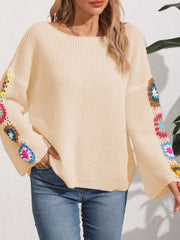 Tan knit sweater with colorful granny square crochet detail on sleeves.