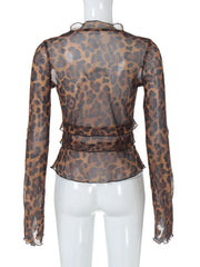 Chic animal print sheer blouse with ruffled neckline and tiered hem detail.