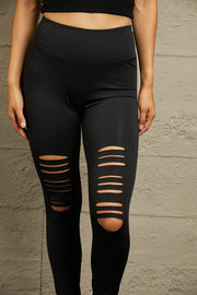 Black performance leggings with distressed knee slits and a comfortable fit.
