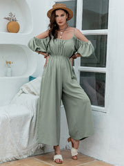 Sage off-shoulder jumpsuit with gathered waist and wide legs, featuring puff sleeves.