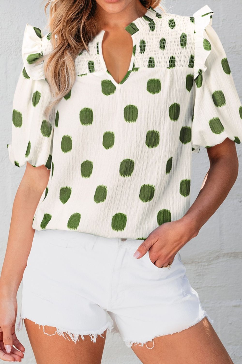 Textured polka dot blouse in matcha green with smocked yoke and ruffled sleeves.