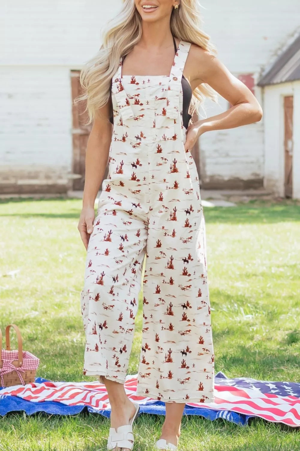 Desert motif adjustable jumpsuit in beige cotton with cropped legs and a desert landscape print.