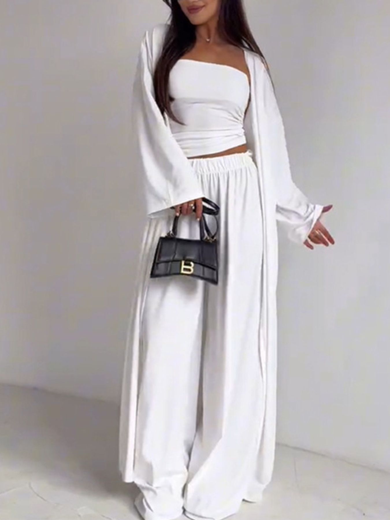 White three-piece outfit set with cardigan, bandeau top, and wide-leg pants.