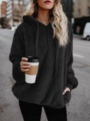 Black cozy fleece hoodie with drawstring and pockets, worn by a woman holding a coffee cup.