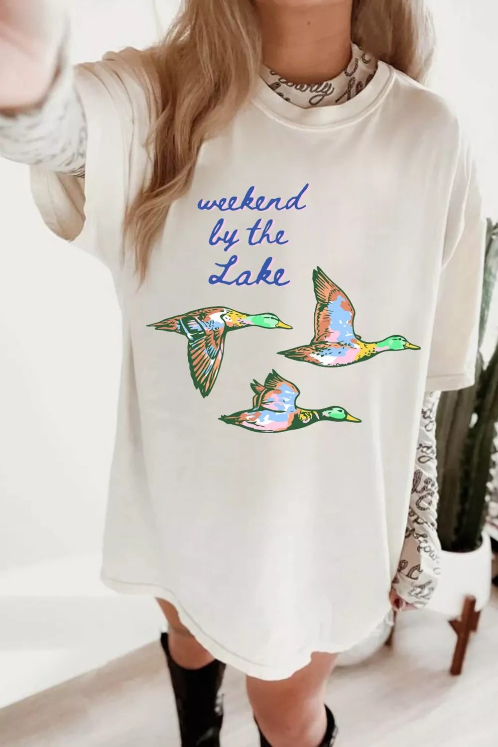 Oversized graphic tee with flying ducks and "weekend by the lake" text, crew neck, short sleeves, cotton.