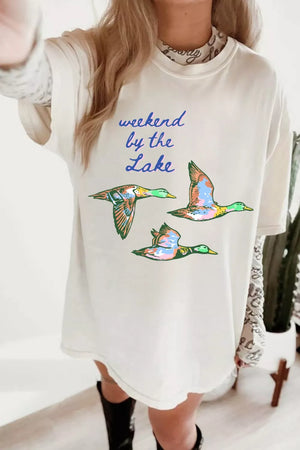 Oversized graphic tee with flying ducks and "weekend by the lake" text, crew neck, short sleeves, cotton.