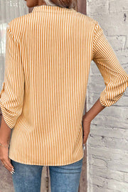 Gold and white vertical stripe blouse with rolled sleeves.