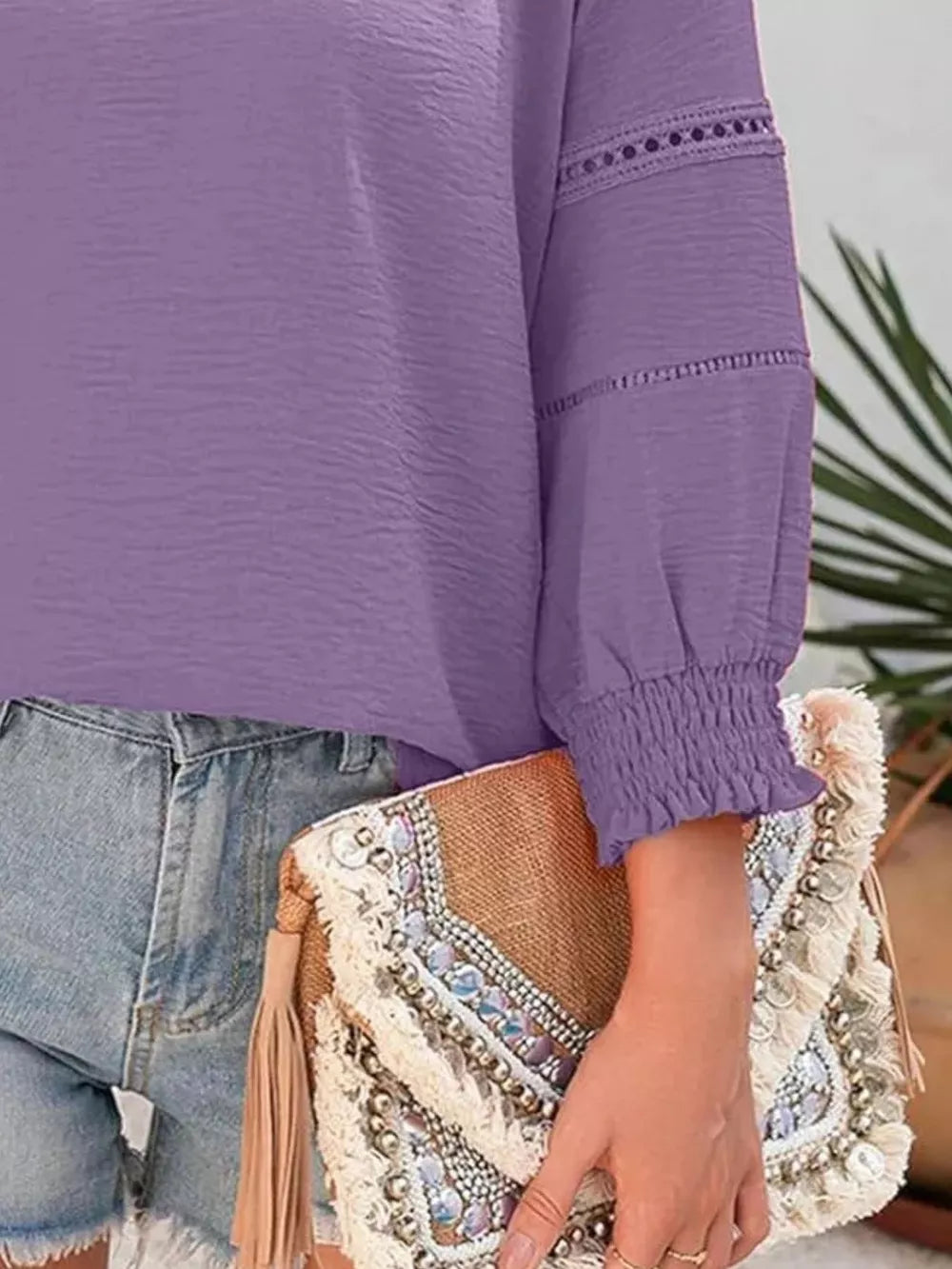 Purple long sleeve blouse with smocked cuffs and lace detail on sleeves.