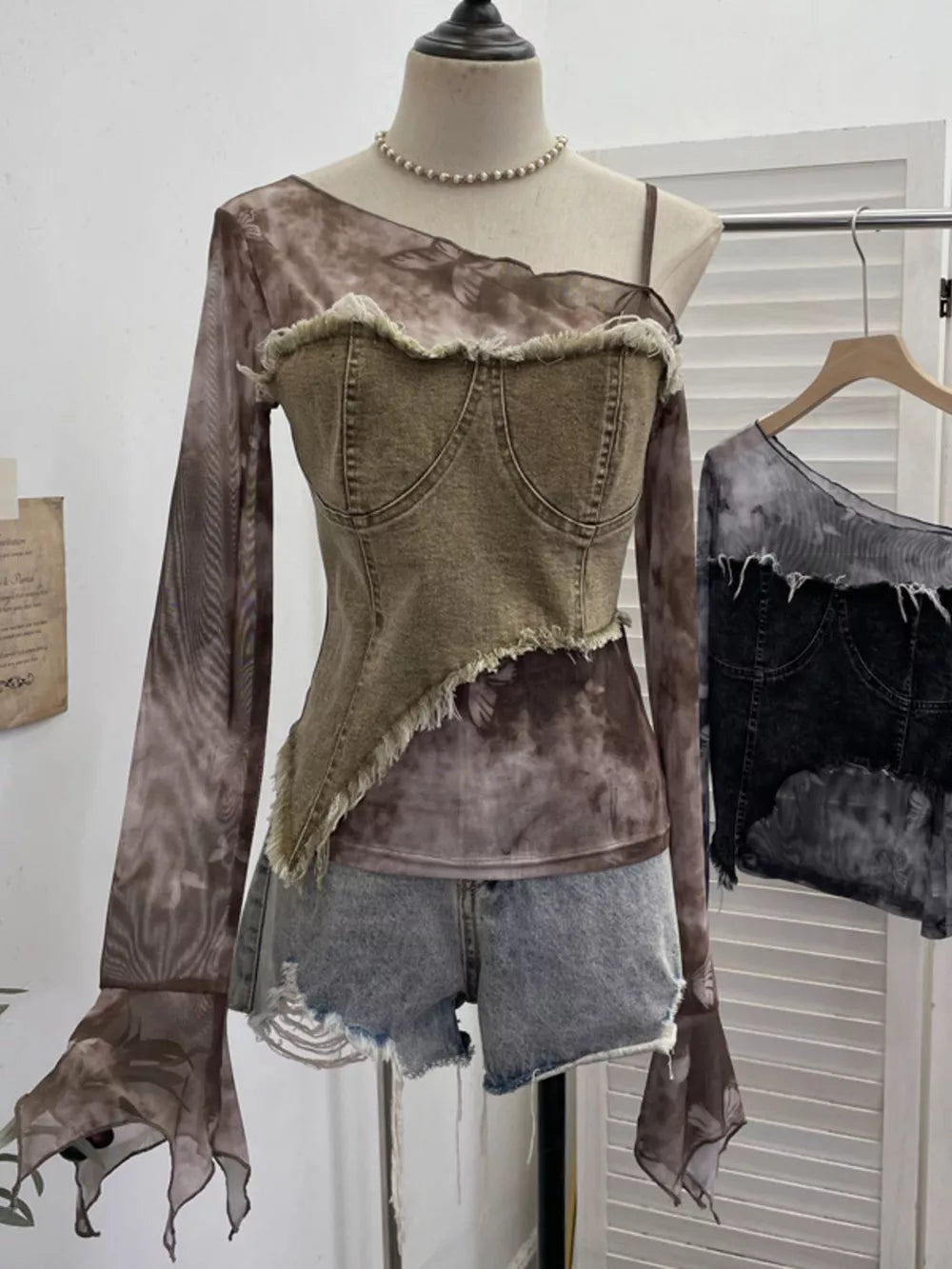 Edgy asymmetrical t-shirt with denim bustier overlay and sheer butterfly print sleeves.