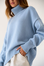 Relaxed Misty Blue knit sweater with a boxy cut and roll-neck collar.