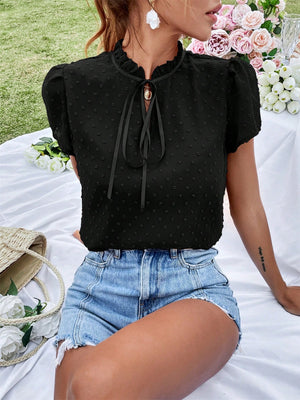 Black dotty frill tie neck blouse with short puff sleeves and ruffled collar.