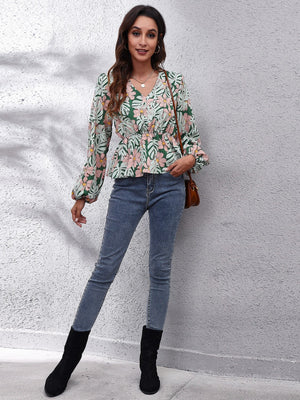 Green tropical print peplum blouse with balloon sleeves and a cinched waist.