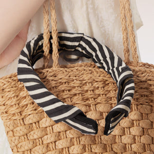 Wide brim sun visor hat with black and white striped fabric detail.