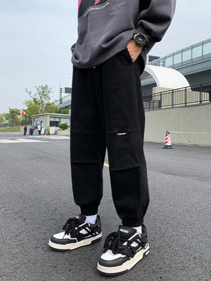 Black relaxed fit joggers with pockets and elastic cuffs.