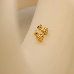 Gold rosebud stud earrings with intricate sculpted detail