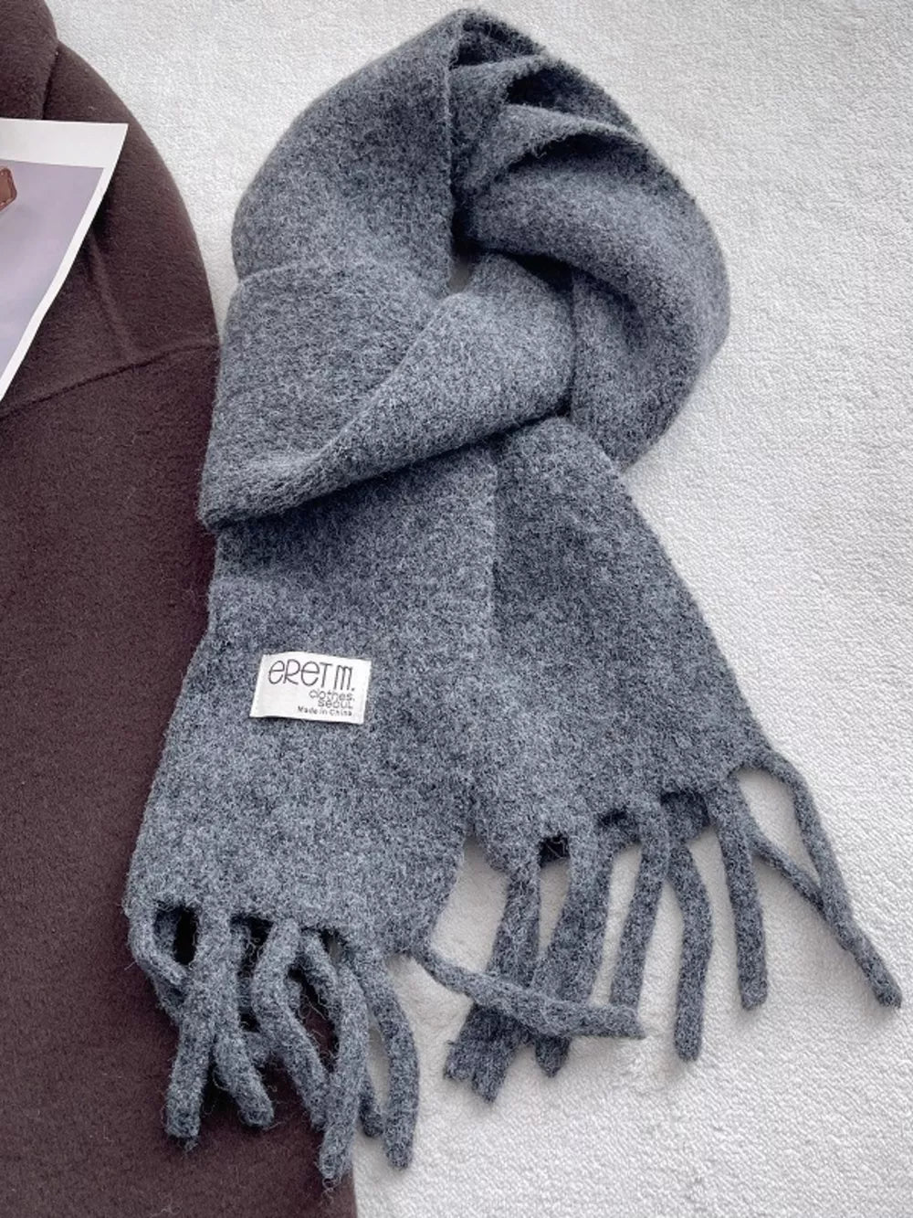 Plush fringe scarf in solid gray with a soft, cozy texture and tasseled ends.