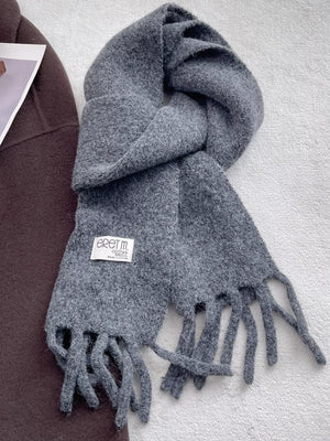 Plush fringe scarf in solid gray with a soft, cozy texture and tasseled ends.