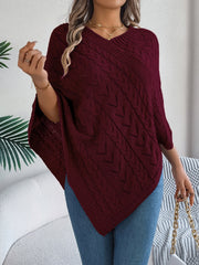 Burgundy cable knit poncho with chevron detail and V-neck, styled with jeans.