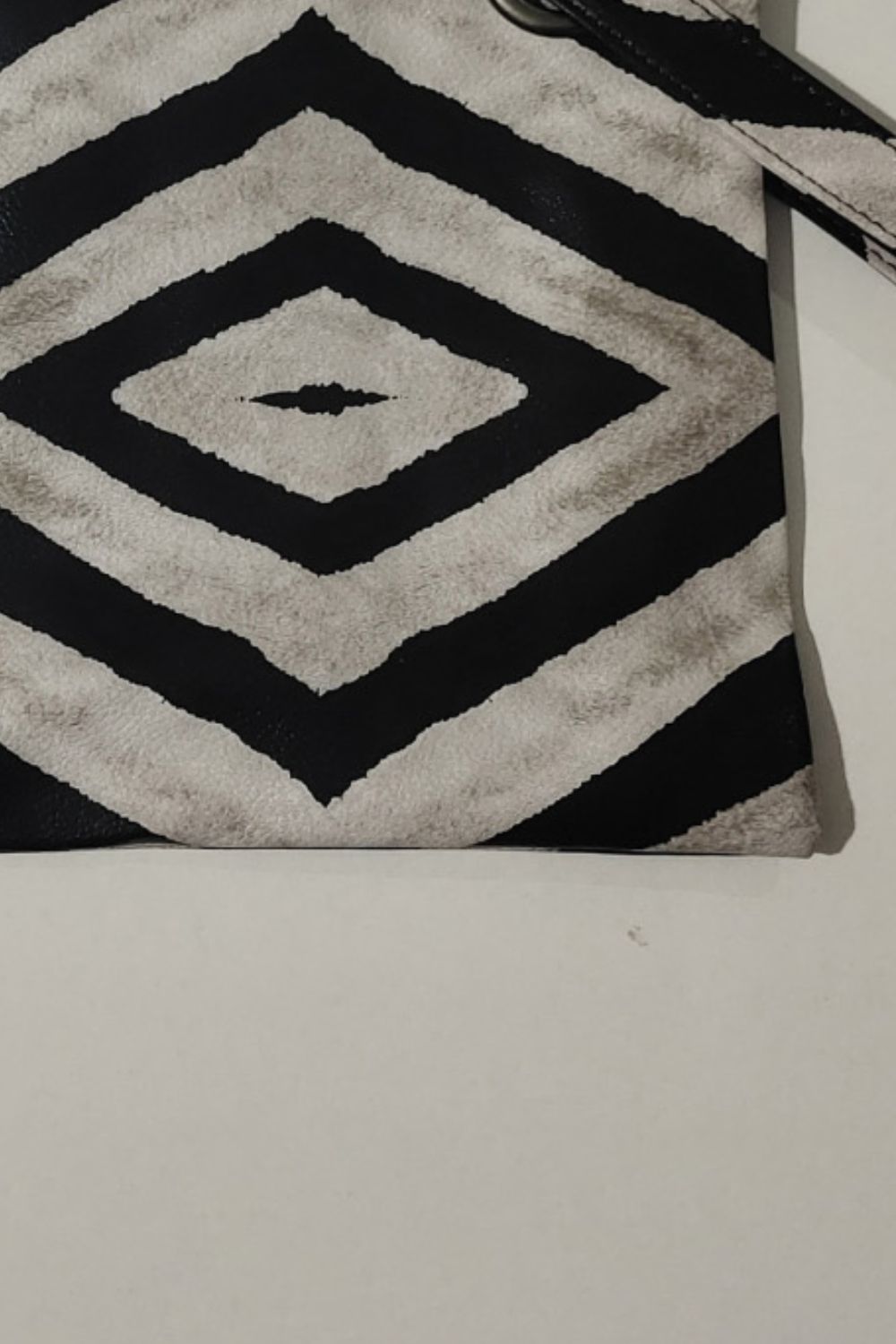 Plaid print wristlet clutch bag in black and cream with grommet detail and strap