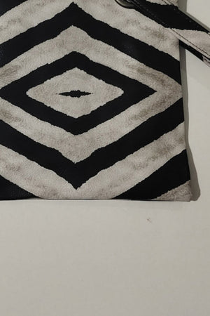 Plaid print wristlet clutch bag in black and cream with grommet detail and strap