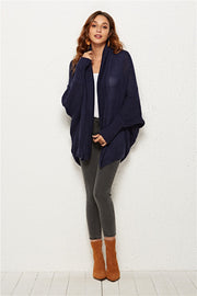 Textured cocoon knit cardigan in dark blue with batwing sleeves and shawl collar.