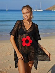 Black crochet beach cover-up with red daisy appliqué and v-neck