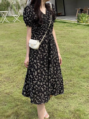 Black botanical print midi dress with puff sleeves and a-line cut.