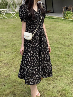 Black botanical print midi dress with puff sleeves and a-line cut.