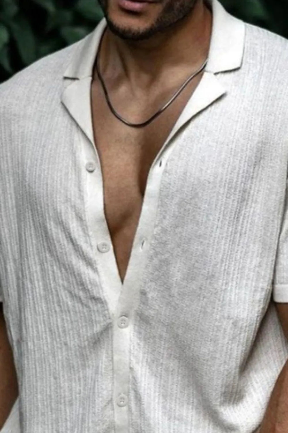 Textured ivory knit resort collar shirt with buttoned placket and short sleeves.