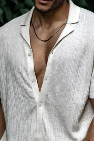 Textured ivory knit resort collar shirt with buttoned placket and short sleeves.