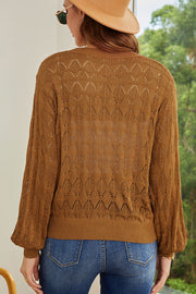 Caramel openwork knit cardigan with balloon sleeves and a diamond pattern.