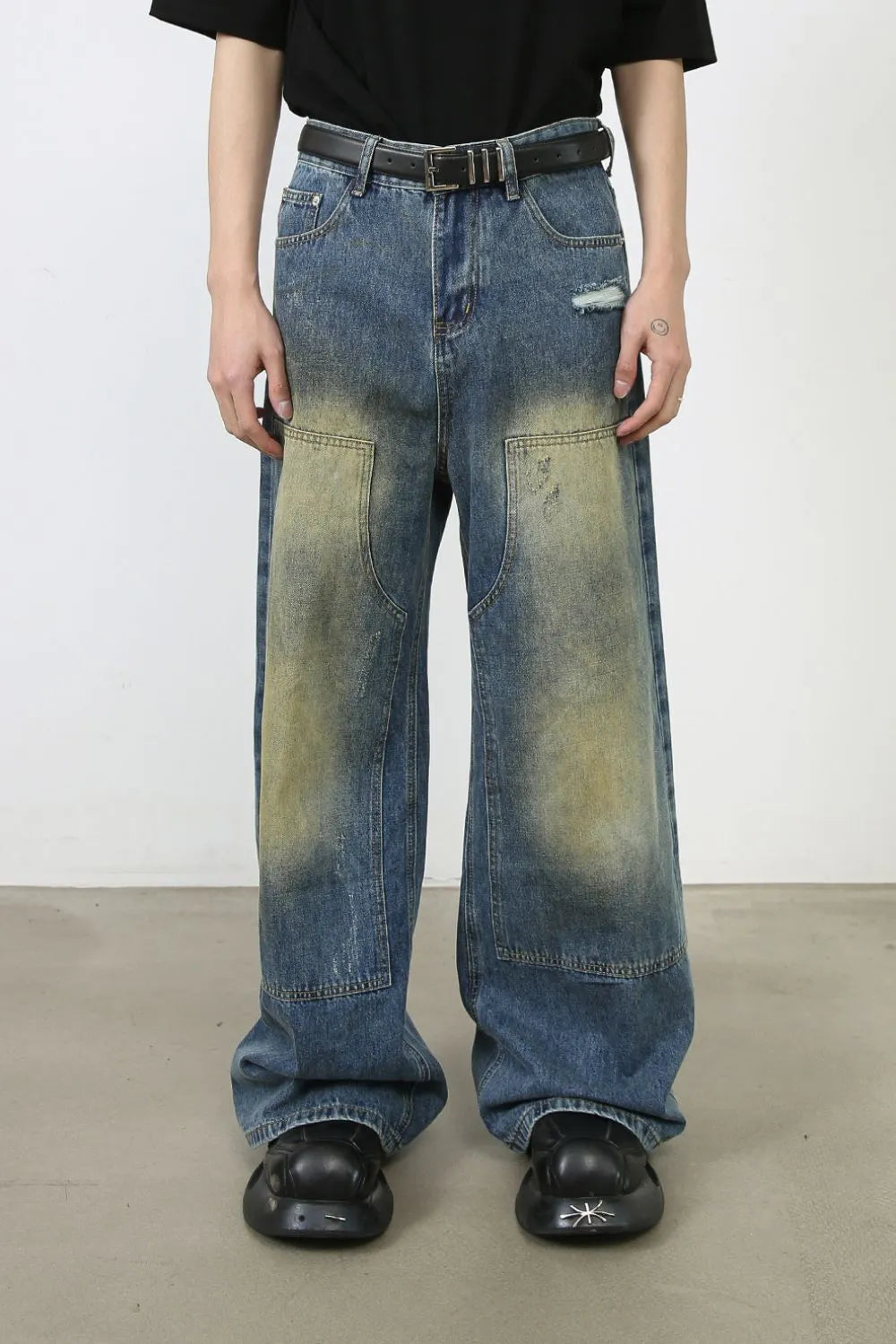 Faded patchwork denim palazzo trousers in medium wash with distressed details and wide legs.